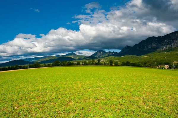法国阿尔卑斯山中围绕着一座富饶农舍的广阔田野 — 图库照片