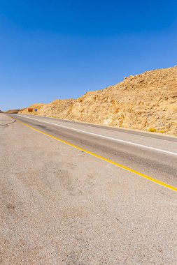 İsrail 'deki Negev çölünün kumlu tepelerinde asfalt yol 