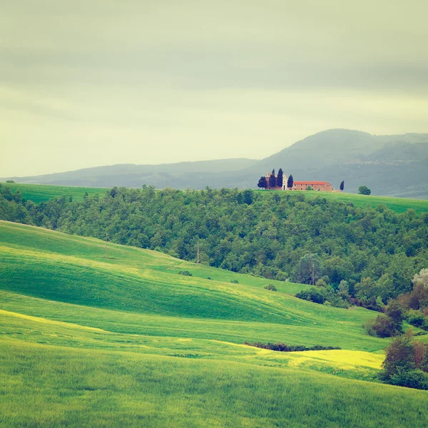 Kyrkan och gröna sluttande ängar i Toscana — Stockfoto