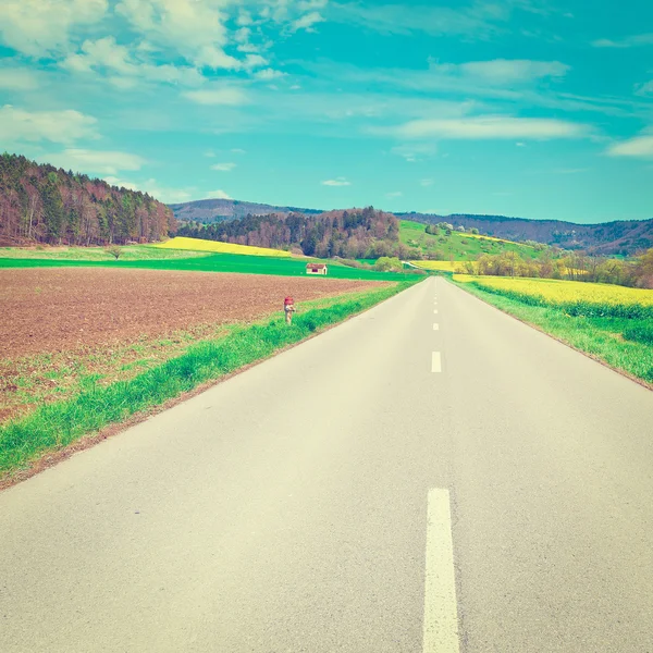 Straße zwischen Feldern — Stockfoto