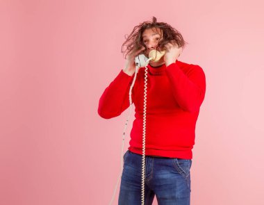 Yetişkin erkek çağrı merkezi çalışanı. Günlük kıyafetler içinde. Telefonlara duygusal olarak cevap veriyor.