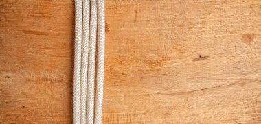 Eski bir meşe ağacı tahtası ve üzerinde bir denizcilik halatı var. Boş bir alanla bir çerçeve oluşturuyor. 