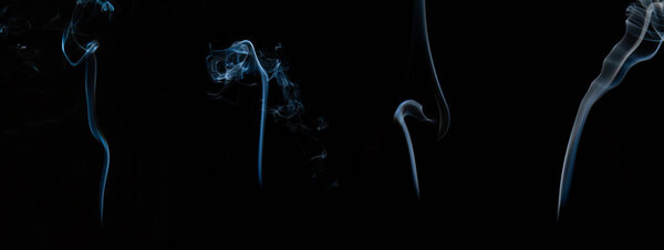 Several different light waves of smoke on a dark background