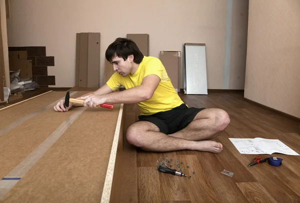 Joven hombre ensamblando muebles — Foto de Stock