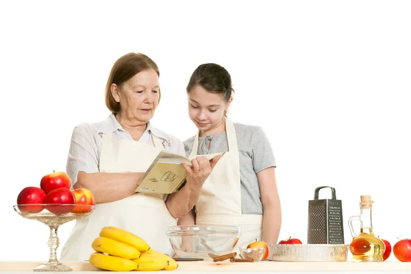 Die Großmutter und die Enkelin lesen das Rezeptbuch — Stockfoto