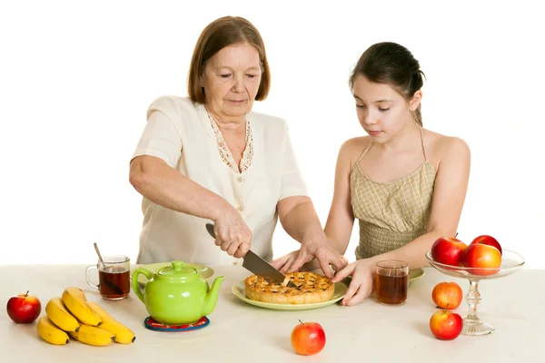 The grandmother treats the granddaughter with pie — Stock Photo, Image