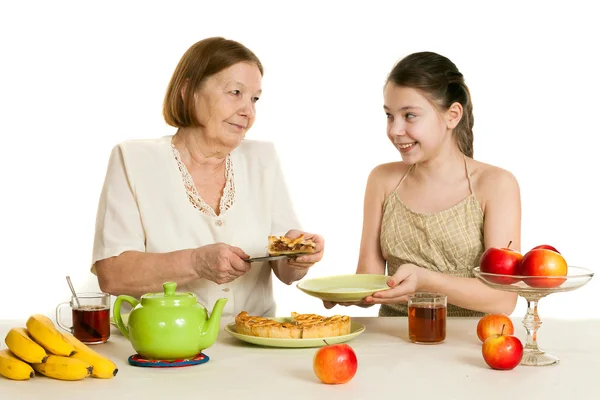 The grandmother treats the granddaughter with pie — Stock Photo, Image