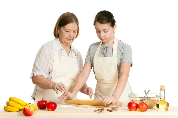 Die Großmutter und die Enkelin rollen Teig — Stockfoto