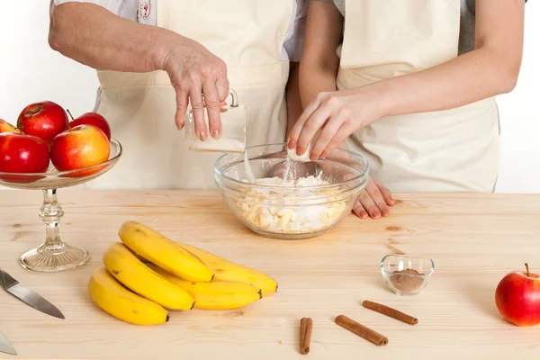 The grandmother and the granddaughter fill ingredients in a bowl — Stock Photo, Image