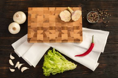 Tahta kesme tahtasında taze sebzeler, otlar ve baharatlar.