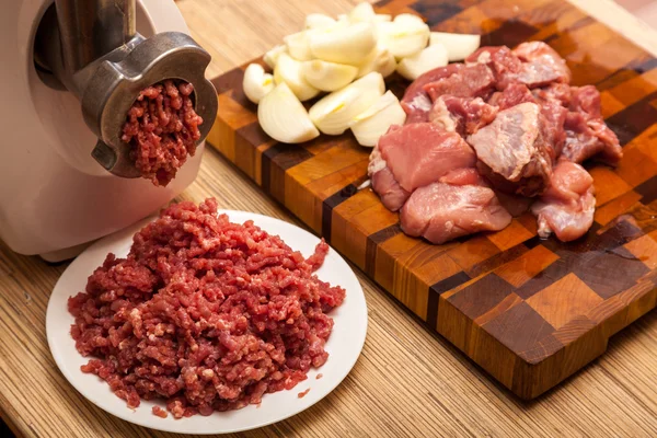 Mlýnek na maso elektrický, sekaná, cibule a kusy masa — Stock fotografie