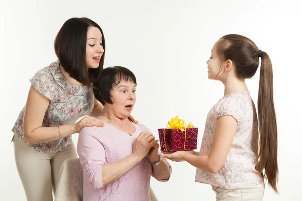 The daughter and the granddaughter give a gift — Stock Photo, Image
