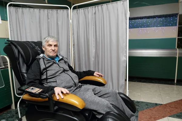 Hombre mayor en una silla de masaje —  Fotos de Stock