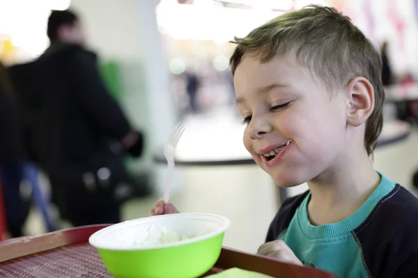 Улыбающийся ребенок ест пельмени — стоковое фото
