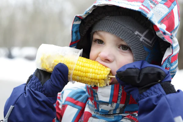 Niño comiendo maíz — Foto de Stock