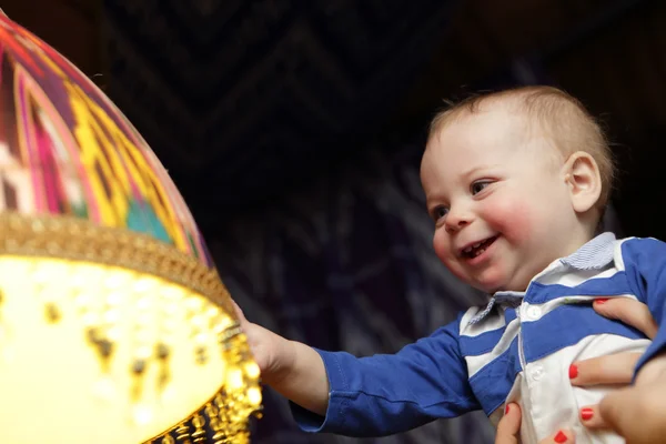 Baby rührt Kronleuchter an — Stockfoto