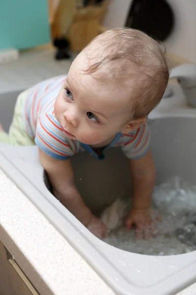 Småbarn som sitter i diskbänken — Stockfoto