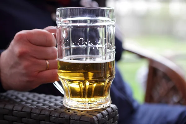 Person holding mug of beer — Stock Photo, Image