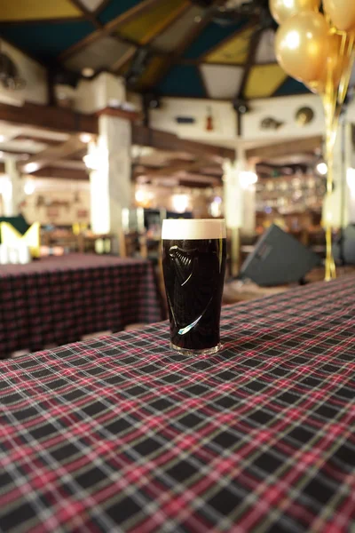 Becher mit dunklem Bier auf einem Tisch — Stockfoto