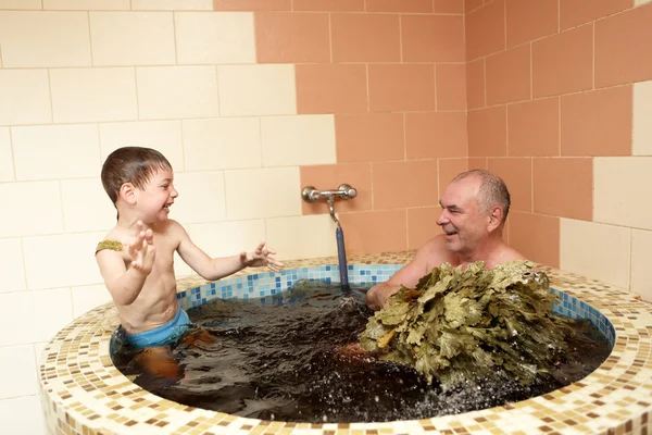 Großvater mit Enkel erfrischt sich im Whirlpool — Stockfoto