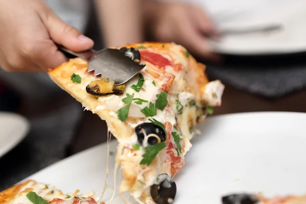 Person takes seafood pizza — Stock Photo, Image