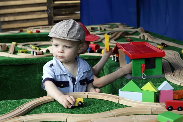 Bambino che gioca con la ferrovia giocattolo — Foto Stock