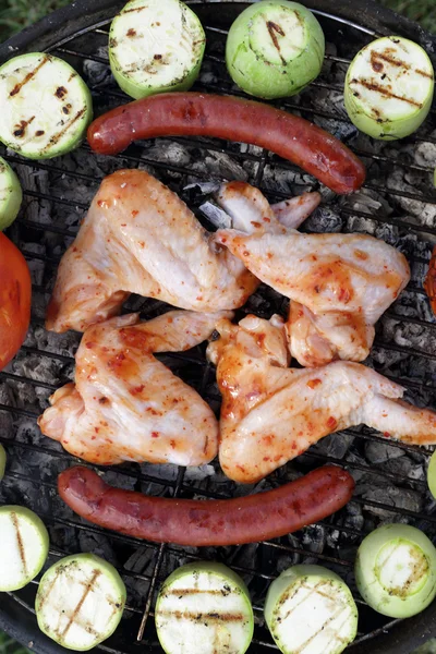 Kippenvleugeltjes met groenten op grill — Stockfoto