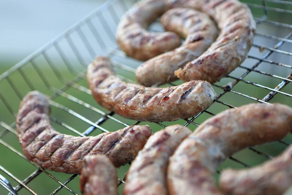 Sausages on grill grate — Stock Photo, Image