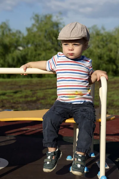 Boy sitting on roundabout — Stock Photo, Image