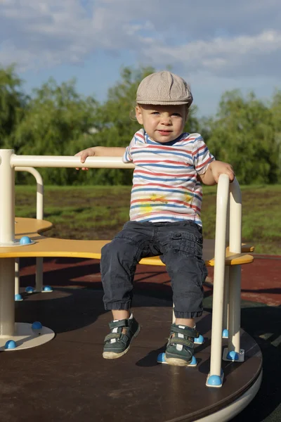 Niño sentado en la rotonda — Foto de Stock