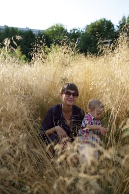 Çim alanda oturan oğlu ile annesi