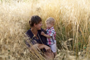 Anne ve oğlu çim alanda oturmuş