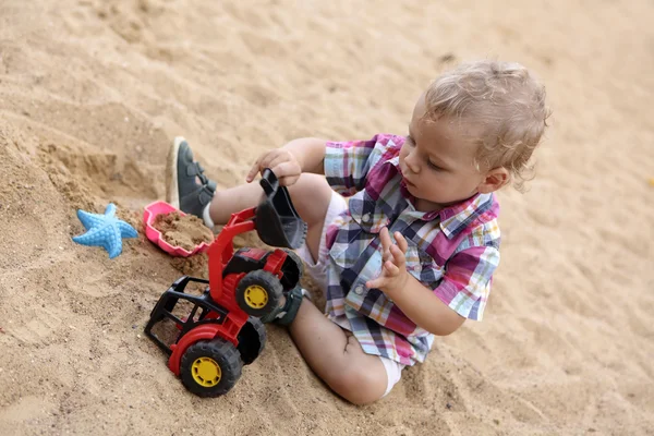 Toddler playing with toy bulldozer — Stock Photo, Image