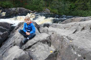 Ruskeala şelalesinin arka planındaki çocuk, Karelia