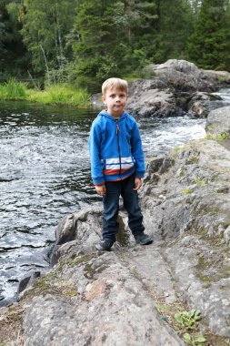 Ruskeala şelalesinin arka planındaki çocuk, Karelia.