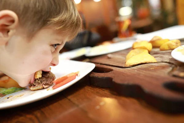 Çocuk Restoranda Tabakta Hamburger Yiyor — Stok fotoğraf