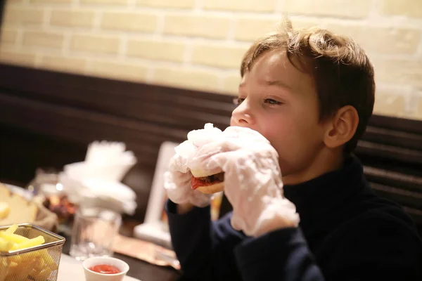 Niño Con Guantes Comiendo Hamburguesa Restaurante — Foto de Stock