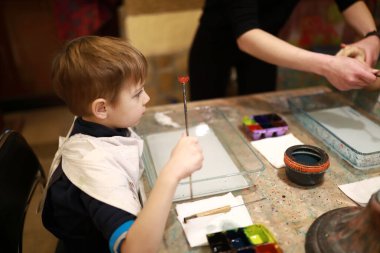 Çocuk atölyede ebru tekniği kullanıyor