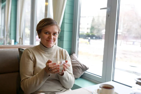 女性保持キャンドルで彼女の手のひらでカフェ — ストック写真