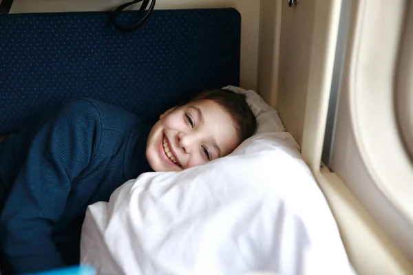 Portrait of child lying in train compartment