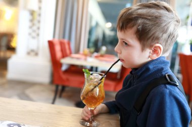 Kafede limonata içen bir çocuğun portresi