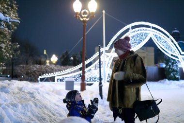 Oğlum, kışın gece annesinin önünde diz çökmüş, Kaza.