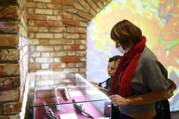母亲和儿子在博物馆里检查古代手枪 — 图库照片