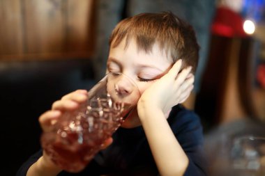 Restoranda meyve suyu içen çocuk portresi