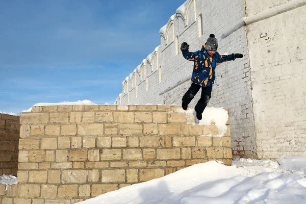 孩子们从俄罗斯喀山克里姆林宫的墙上跳到雪地上 — 图库照片