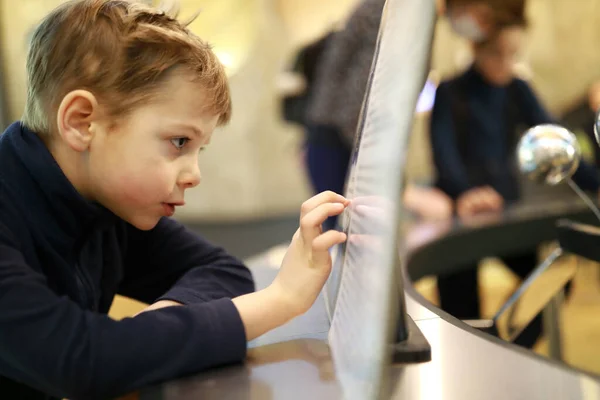 博物館のタッチスクリーンを使用した好奇心の子供 — ストック写真