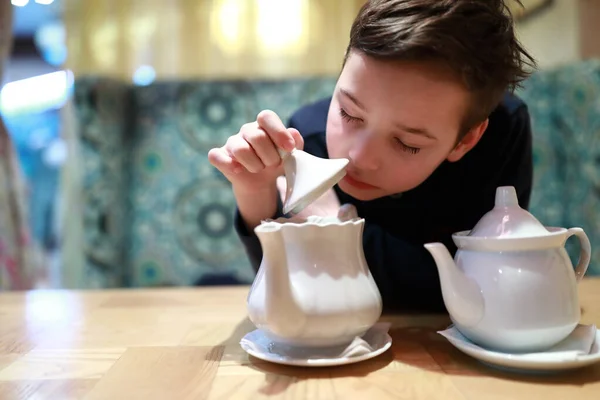 Child checks brewing of tea in restaurant