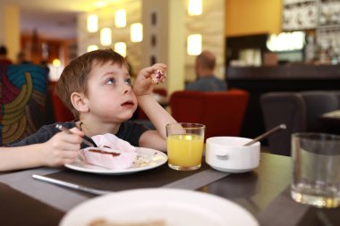 Çocuk kahvaltıda tatlı yer.