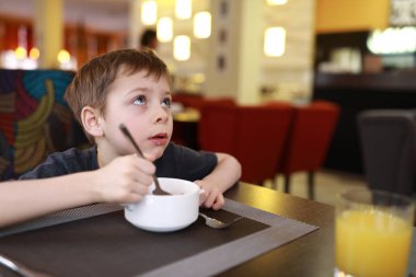 Çocuk portresi restoranda kahvaltı yapıyor.
