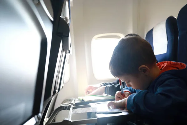 Child drawing on airplane during the flight